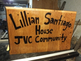 sign for the Jesuit Volunteer Community in Camden. Made from the end of an abandoned Holy Name pew